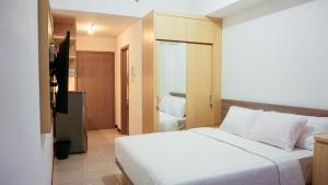 a bedroom with a large white bed in a room at Cordova Suites in Semarang