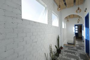 a white brick wall in a hallway with stairs at Cube homestay Phan Rang cách biển 300m to the beach in Phan Rang