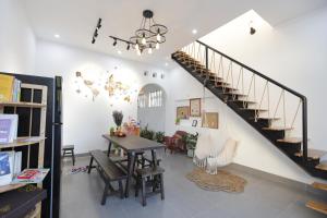 a living room with a table and a staircase at Cube homestay Phan Rang cách biển 300m to the beach in Phan Rang