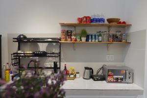 a kitchen with a counter with a microwave and shelves at Cube homestay Phan Rang cách biển 300m to the beach in Phan Rang