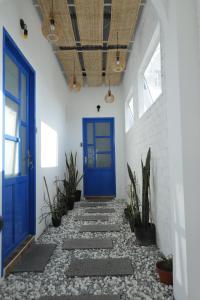 a hallway with a blue door and some plants at Cube homestay Phan Rang cách biển 300m to the beach in Phan Rang