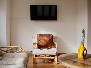 a living room with a chair and a tv on a wall at Ca Blai de Brull en el centro de Tivissa in Tivissa