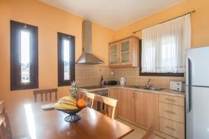 a kitchen with a table with a bowl of fruit on it at Villa Angela in Skiathos
