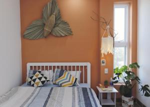 a bedroom with orange walls and a bed with pillows at Cube homestay Phan Rang cách biển 300m to the beach in Phan Rang