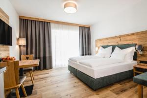 um quarto de hotel com uma cama e uma secretária em Kopeindlgut Apartments em Wals