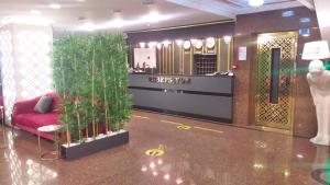 een lobby met een rode bank en planten erin bij Yilmazel Hotel in Gaziantep