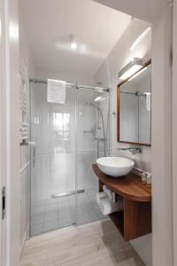 a bathroom with a glass shower and a sink at W Sercu Krakowa Aparthotel in Krakow