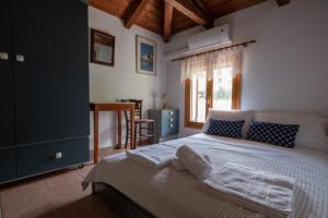 a bedroom with a bed with blue cabinets and a window at Villa Eirini with sea view in Dhriópi