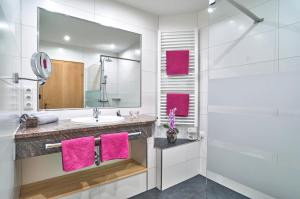 a bathroom with a sink and a mirror and pink towels at Landhaus Florian in Bodenmais +19 photos