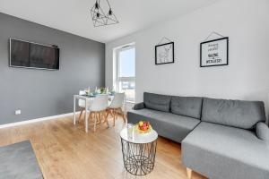 a living room with a couch and a table at Apartament Bastion Sky Gdańsk TriApart in Gdańsk
