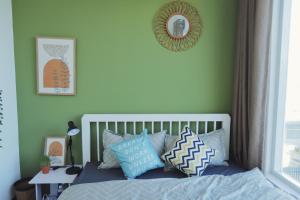 a bed with blue pillows in a green bedroom at Cube homestay Phan Rang cách biển 300m to the beach in Phan Rang