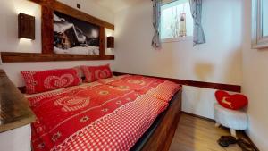 ein Schlafzimmer mit einem roten Bett in einem Zimmer in der Unterkunft AlpinDesign Kaunertal in Kaunertal