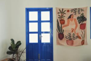 a blue door in a room with a painting on the wall at Cube homestay Phan Rang cách biển 300m to the beach in Phan Rang