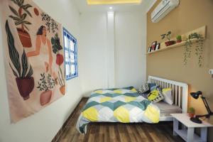 a bedroom with a bed and a painting on the wall at Cube homestay Phan Rang cách biển 300m to the beach in Phan Rang