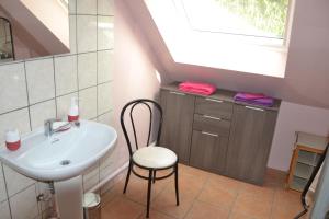 a bathroom with a sink and a chair and a window at Les Talents Aiguilles in Breuil-sur-Vesle