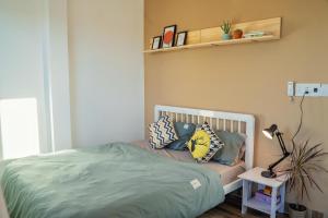 a bed with pillows on it in a bedroom at Cube homestay Phan Rang cách biển 300m to the beach in Phan Rang