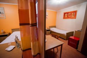 Cette petite chambre comprend deux lits et une table. dans l'établissement Angelis Pension, à Kelsterbach