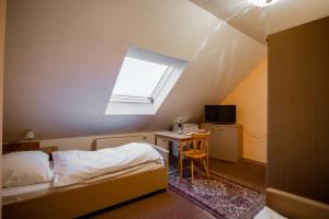 a bedroom with a bed and a table and a window at Angelis Pension in Kelsterbach