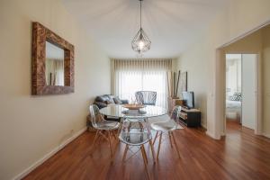uma sala de estar com uma mesa e cadeiras e um espelho em Apartamento Newark em Matosinhos