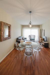 een woonkamer met een glazen tafel en stoelen bij Apartamento Newark in Matosinhos