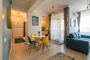 sala de estar con sofá, mesa y sillas en Mayor Apartment Faleza Nord, en Constanţa
