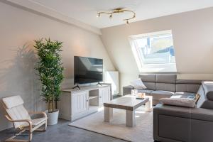 een woonkamer met een bank en een tv bij Spacious apartment in the heart of Ostend near the sea in Oostende