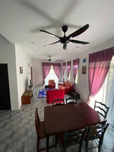a living room with a table and a ceiling fan at LMS homestay in Alor Setar