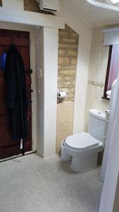 a bathroom with a white toilet and a door at Ruby Cottage in Irthlingborough