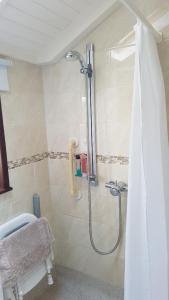 a bathroom with a shower with a shower curtain at Ruby Cottage in Irthlingborough