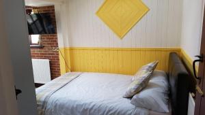 a bedroom with a bed with a pillow on it at Ruby Cottage in Irthlingborough