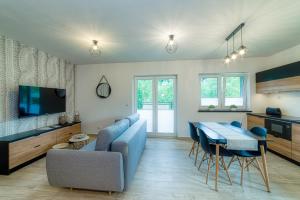 salon z niebieską kanapą i stołem w obiekcie APARTAMENTY NA SKARPIE w mieście Szczawnica