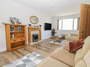 a living room with a couch and a fireplace at The Croft Bungalow in Wigton