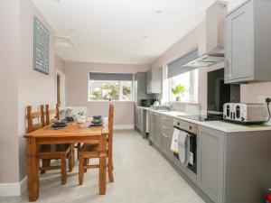 a kitchen with a wooden table and a dining room at The Croft Bungalow in Wigton