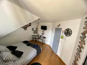 a room with a bed and a table with a clock on the wall at Chez Kate et lolo in Senneville-sur-Fécamp
