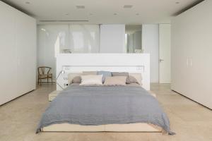 a large white bedroom with a large bed in it at PALMA BAY FRONT LINE in Llucmajor