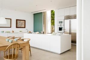 a kitchen with white cabinets and a wooden table at PALMA BAY FRONT LINE in Llucmajor