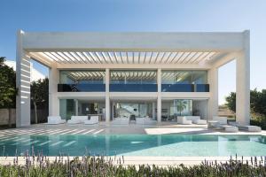 a large house with a swimming pool in front of it at PALMA BAY FRONT LINE in Llucmajor