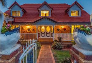 uma casa com um telhado vermelho e um portão em Mountain Living with Ocean views em Mount Tamborine
