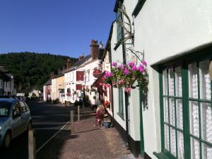 um edifício com flores ao lado de uma rua em 29 High Street Dunster em Minehead