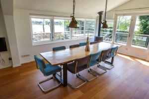 a dining room with a wooden table and chairs at Villa-am Wasser- Wellness-NationaalPark- in Earnewâld