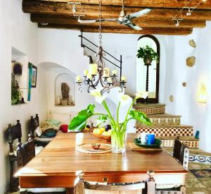 uma sala de jantar com uma mesa de madeira e um lustre em HEAVEN PUERTA CERRADA Casas Vejer Debra em Vejer de la Frontera