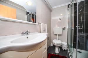 une salle de bain avec un lavabo, des toilettes et une douche dans l'établissement ManelMar O Refúgio, à Nazaré 35 autres photos