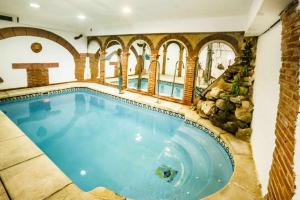 - une grande piscine dans un bâtiment avec un mur en pierre dans l'établissement Casa Rural Spa La Chirumba, à Aldeatejada