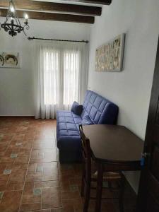 a living room with a blue couch and a table at Casa del Molino in Titulcia