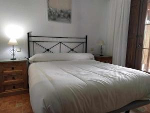 um quarto com uma cama grande e duas mesas de cabeceira em Casa del Molino em Titulcia
