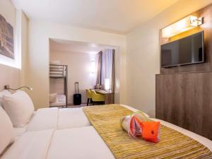 een hotelkamer met een bed en een flatscreen-tv bij Mercure Oostende in Oostende