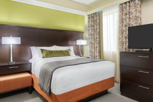 a bedroom with a bed and a flat screen tv at Staybridge Suites - Miami International Airport by IHG in Miami