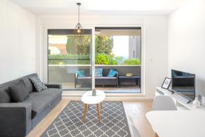 uma sala de estar com um sofá e uma mesa em LUX Holiday Apartment on KASUNI Beach in Split em Split
