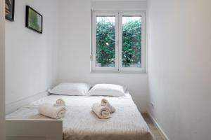 um quarto branco com uma cama com toalhas em LUX Holiday Apartment on KASUNI Beach in Split em Split