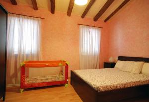 a bedroom with a bed with a baby in it at Ca lHorténsia in Rourell